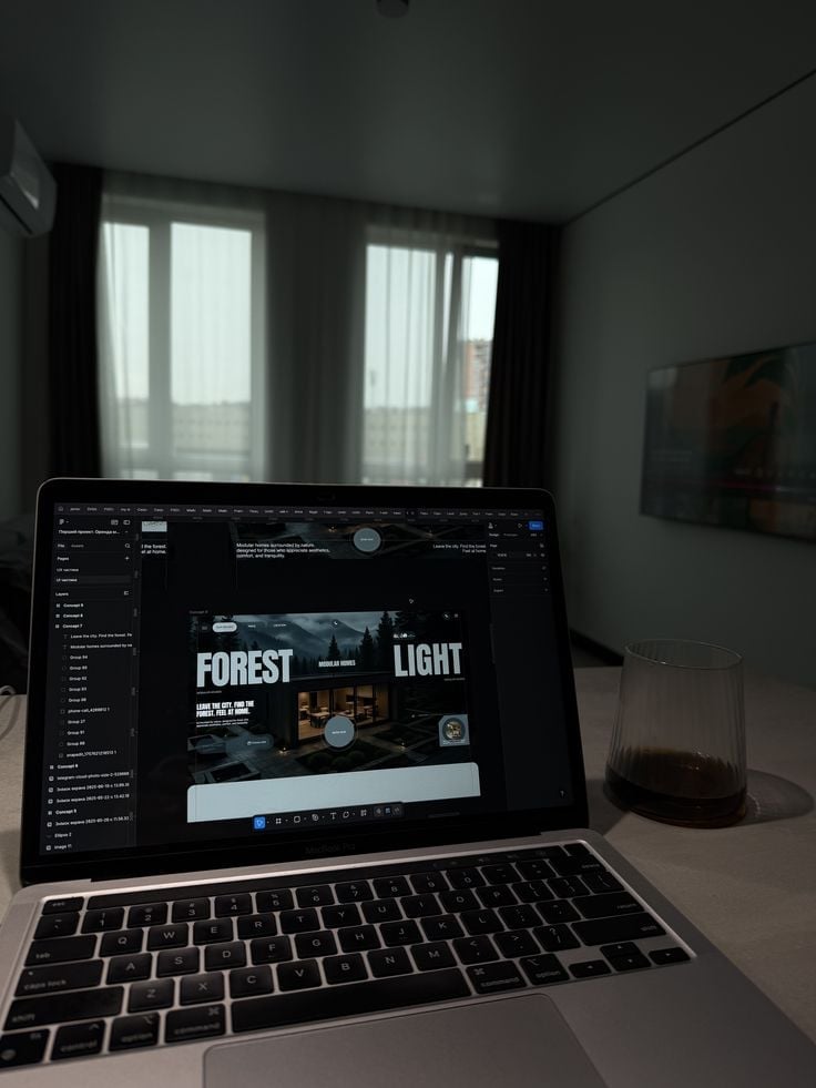 Laptop displaying design software with Forest Light project in a modern bedroom with large windows and wall-mounted screen